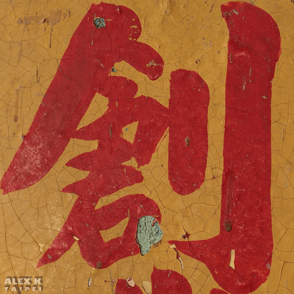 Chinese character painted in red color on a yellow wall