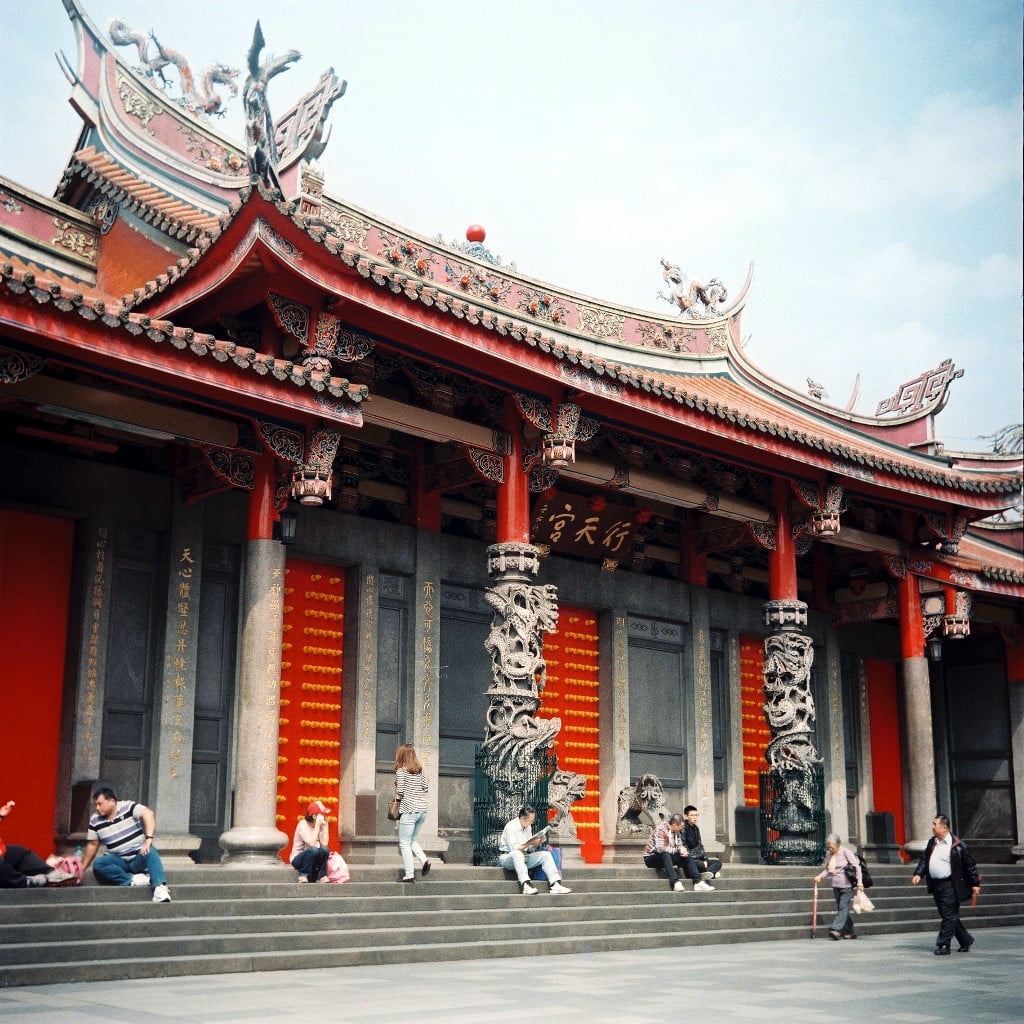 People sitting on the stairs in Xingtian Temple, Taipei City