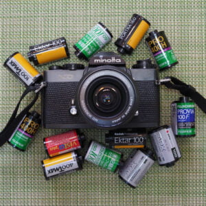 Film camera surrounded by film cartridges